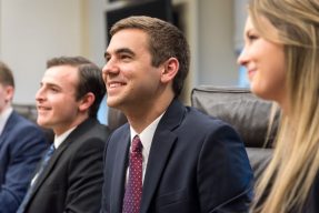 Pitt Business students smiling at a conference room table