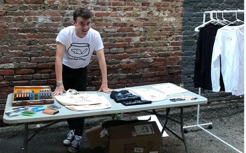 Student Connor Murray selling cassette tapes and merchandise at a table