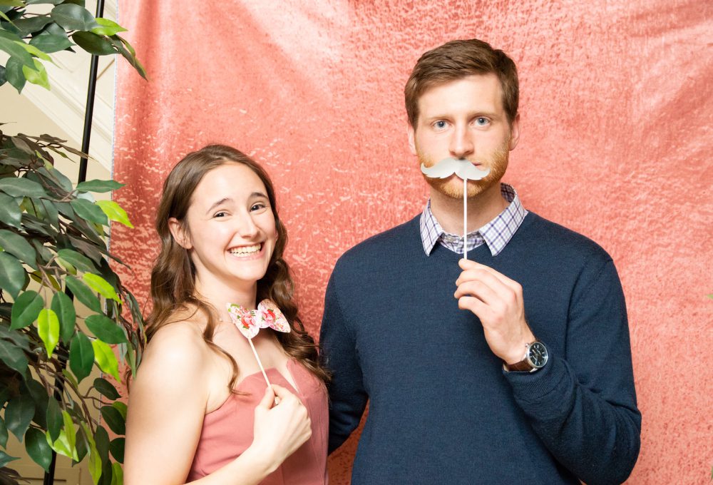 A boy and a girl stand together in the photo booth