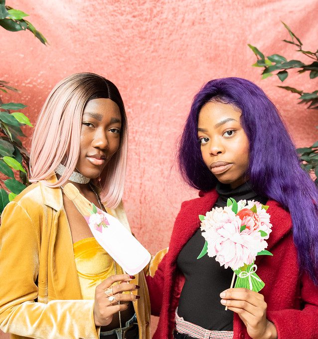 Two girls stand together in the photo booth