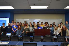The class gathers in the front of the room together