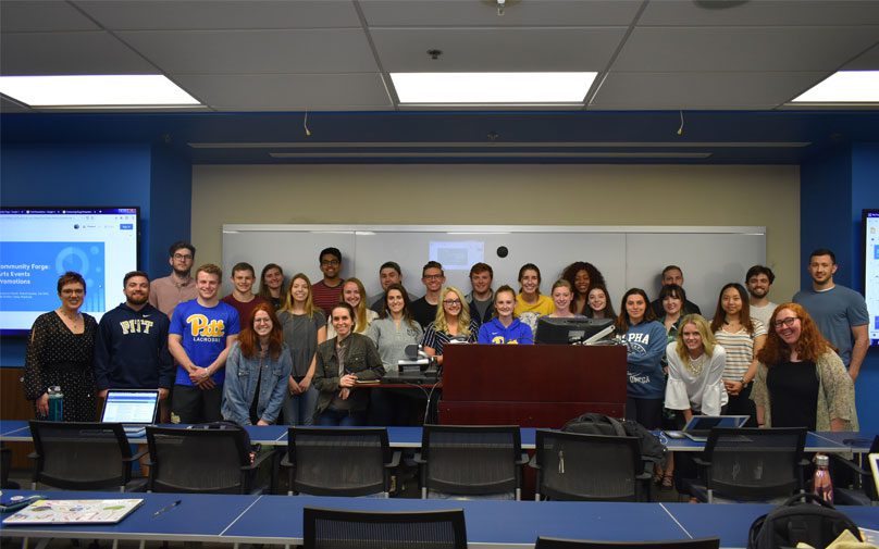 The class gathers in the front of the room together