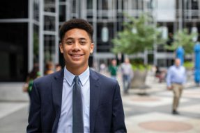 A male student standing in the Market Square of Pittsburgh