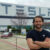 Student poses in front of Tesla facility buildilng