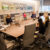 Students and employees of JLL gather around the conference room table for a session.